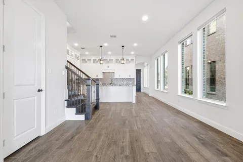a view of a hallway with wooden floor and entryway
