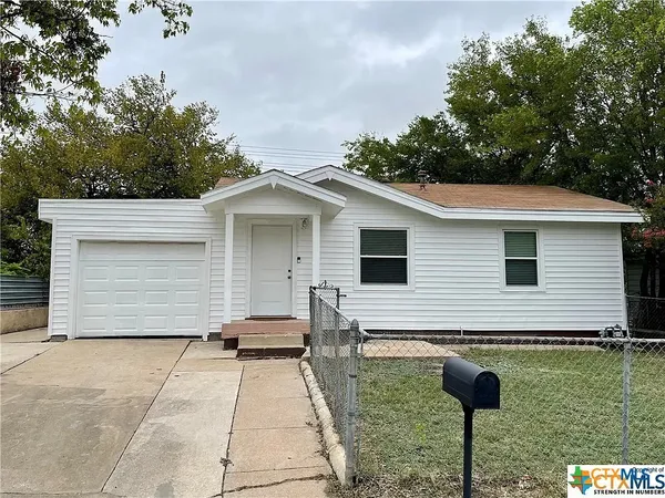 a backyard of a house with barbeque oven and garage