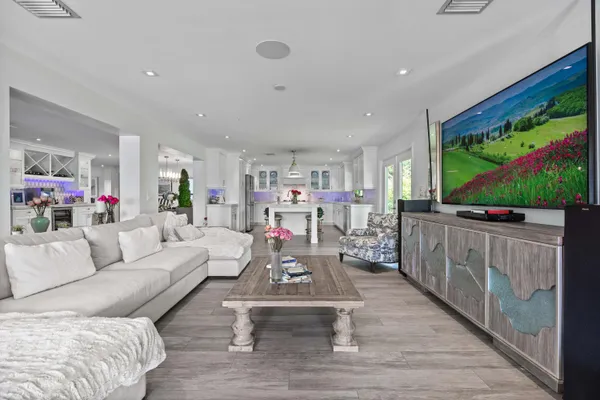 a kitchen with stainless steel appliances kitchen island granite countertop a table chairs in it and wooden floors