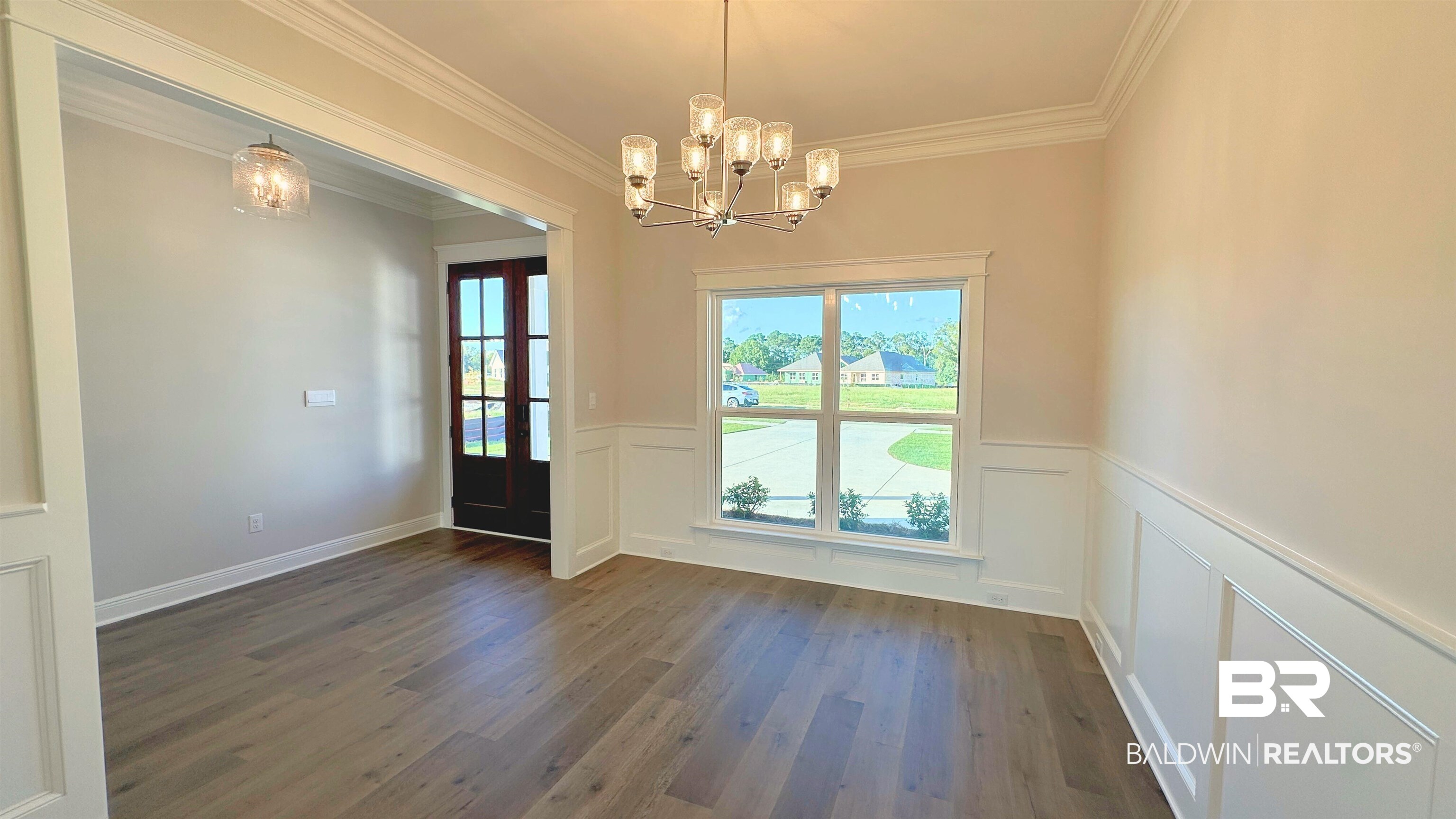 126 Daybreak Trail Fairhope, AL 36532 - Photo 4 of 34 Entryway featuring healthy amount of natural light, crown molding, a chandelier, wood finished floors, and a decorative wall