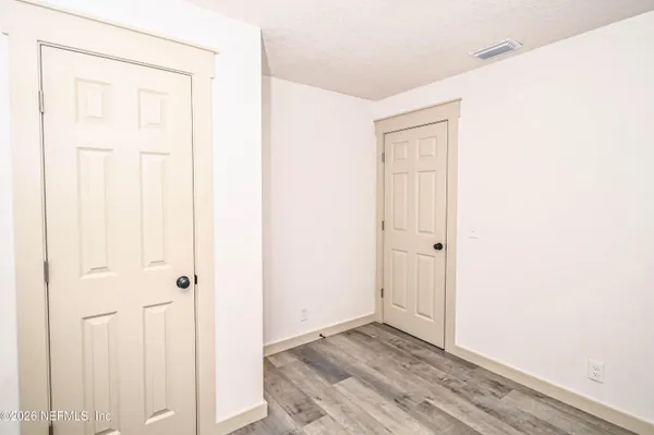 a view of empty room with wooden floor