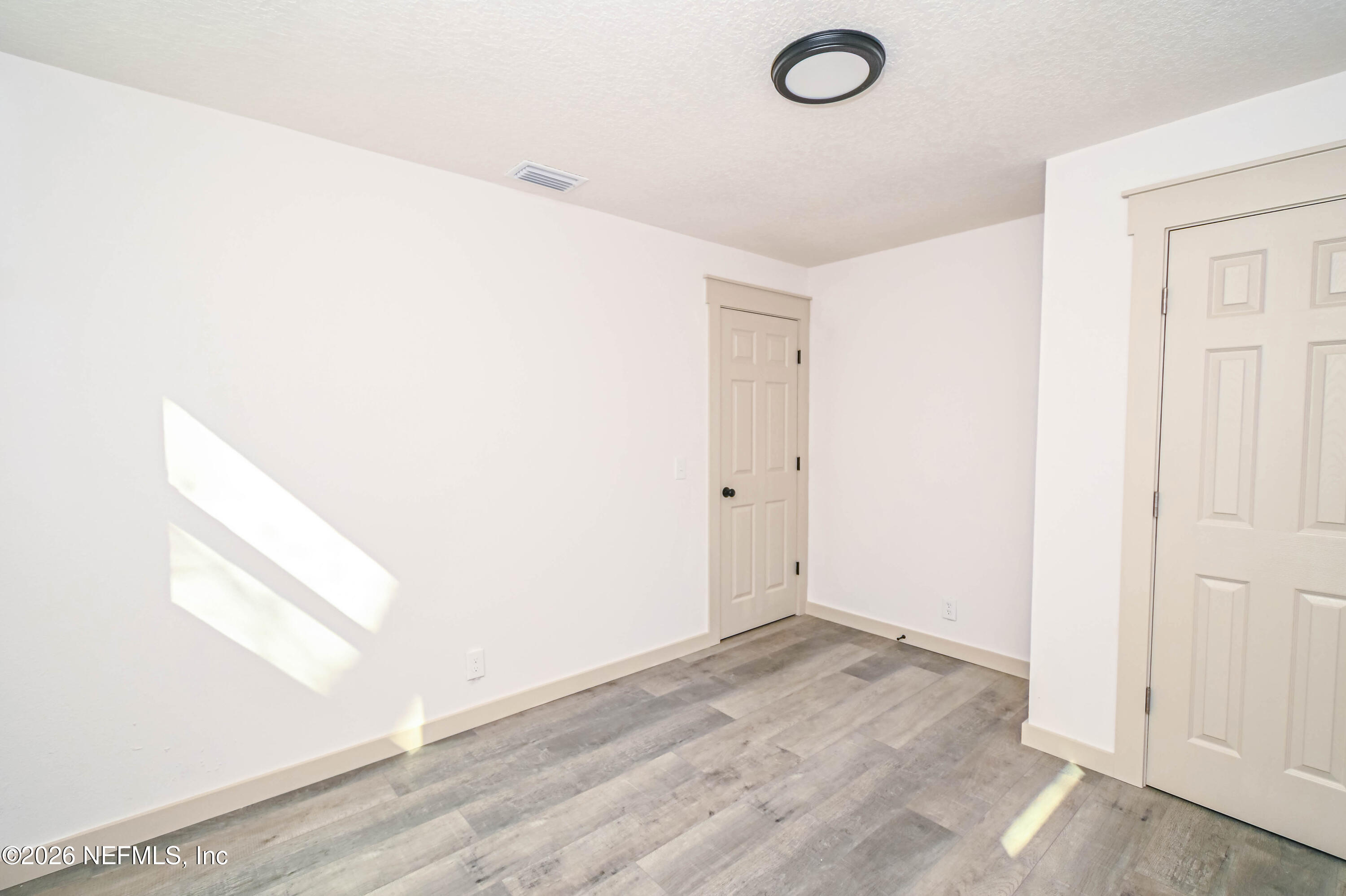 406 Barbara Circle Macclenny, FL 32063 - Photo 18 of 31 an empty room with wooden floor and windows