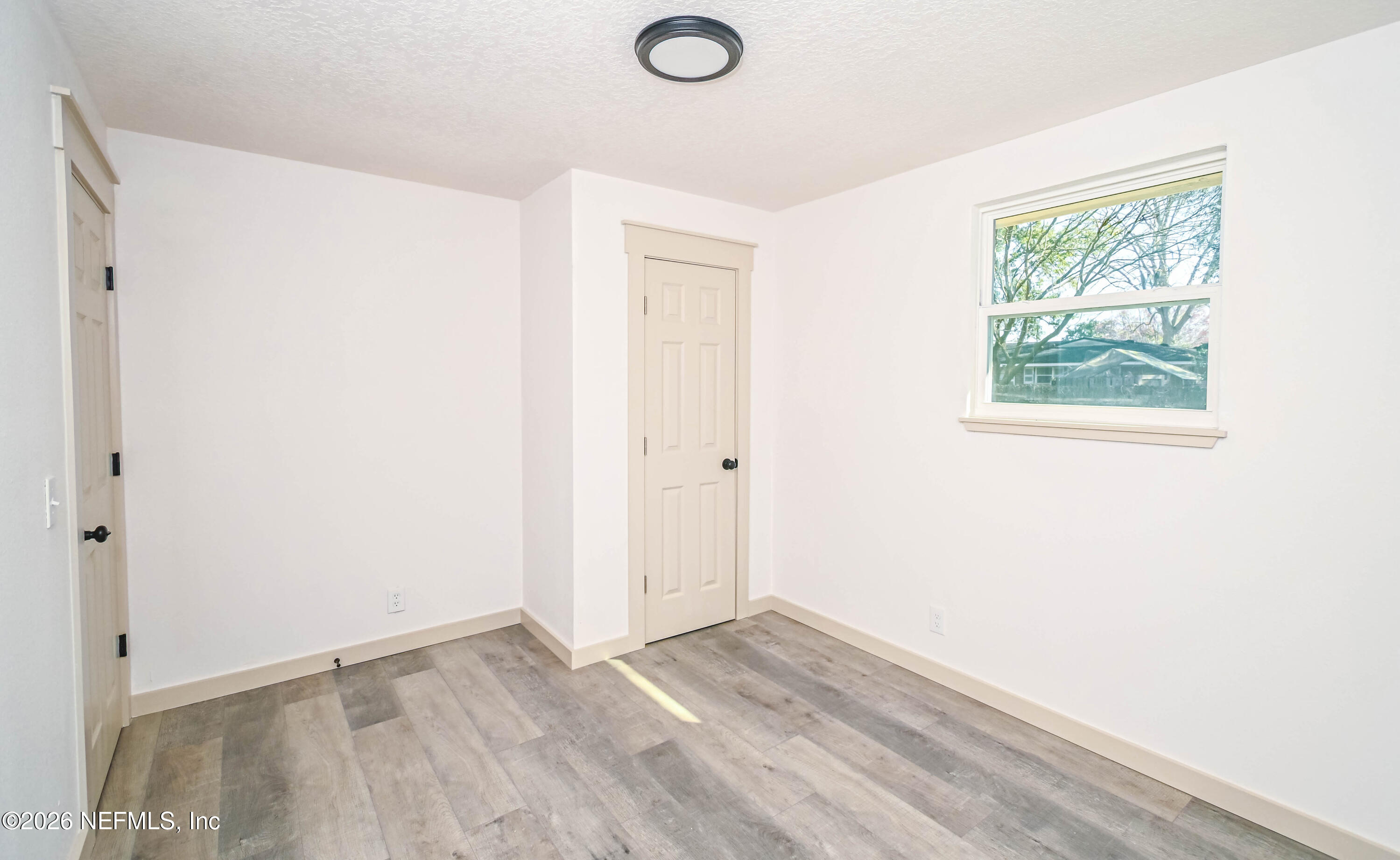 406 Barbara Circle Macclenny, FL 32063 - Photo 19 of 31 an empty room with wooden floor and windows