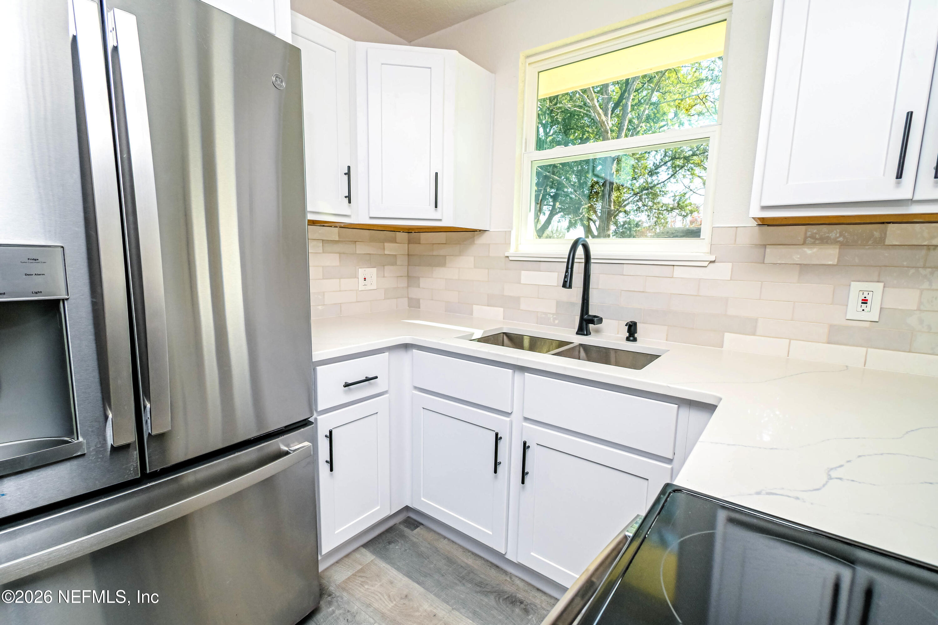 406 Barbara Circle Macclenny, FL 32063 - Photo 6 of 31 a kitchen with a sink a refrigerator and window