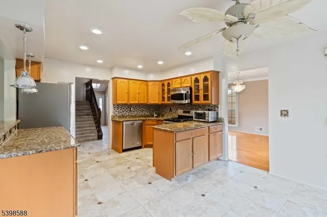 a kitchen with granite countertop a refrigerator and a sink