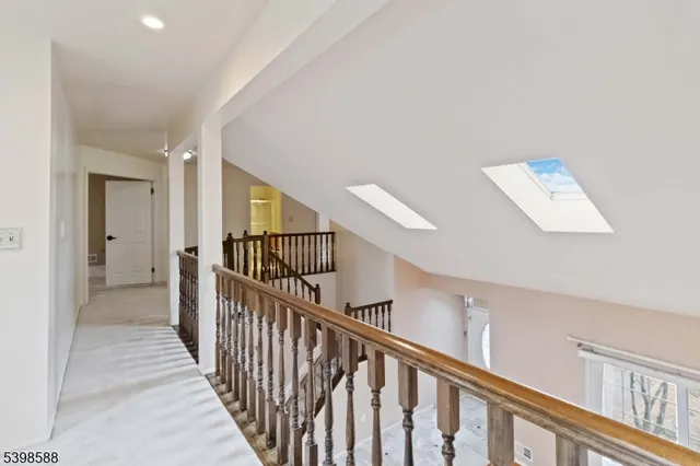 a view of a hallway with wooden floor and stairs