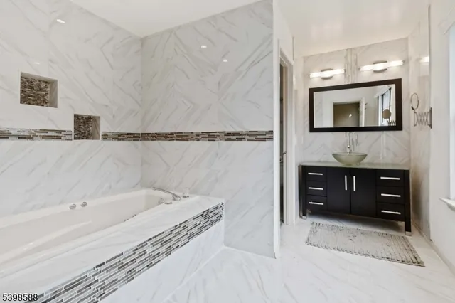 a bathroom with a tub sink and mirror