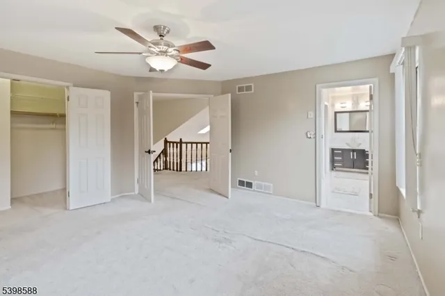 an empty room with closet and windows