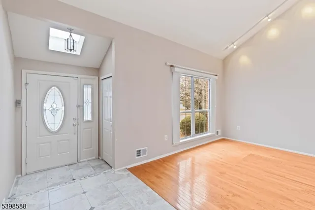 a view of a room with wooden floor and a window