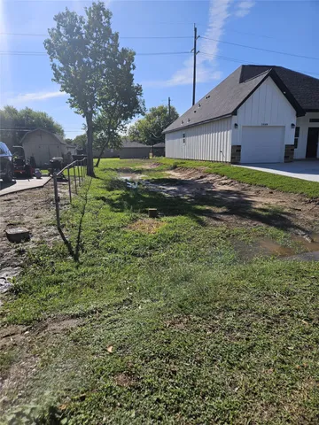 a view of a house with a big yard and large trees