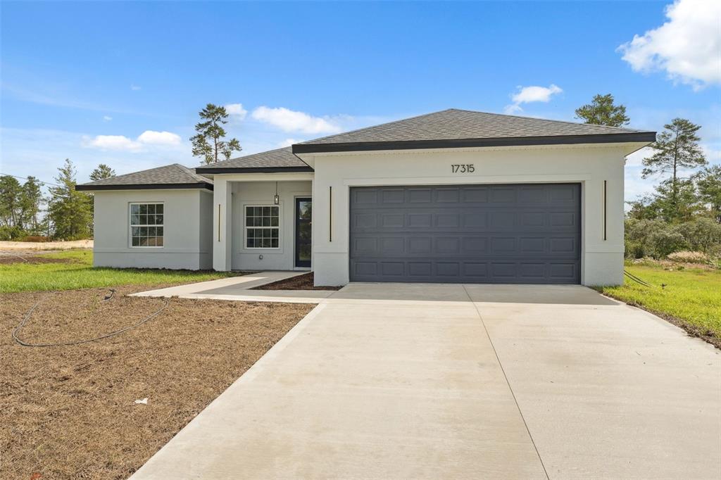17315 Southwest 26th Terrace Road Ocala, FL 34473 - Photo 1 of 1 a front view of a house with a yard and garage