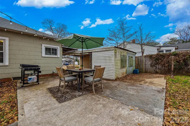 a view of a house with backyard and sitting area