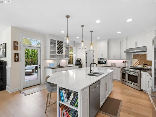 a large kitchen with stainless steel appliances granite countertop a stove oven and a center island