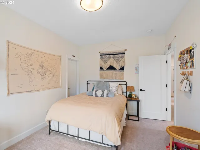 a bedroom with a bed and painting on the wall