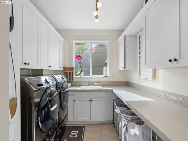 a utility room with cabinets washer and dryer