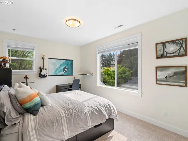 a bedroom with a bed and a painting on the wall