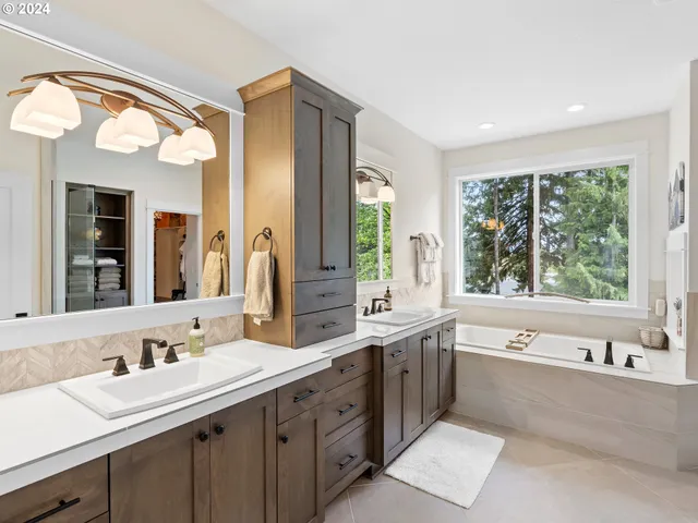 a large bathroom with a large tub sink and mirror