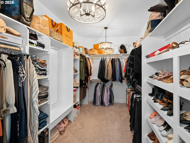a view of walk in closet with clothes and shoes