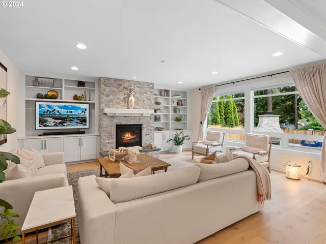 a living room with furniture large window and a fireplace