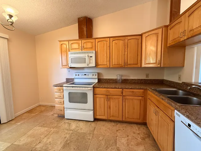a kitchen with granite countertop a sink and a stove