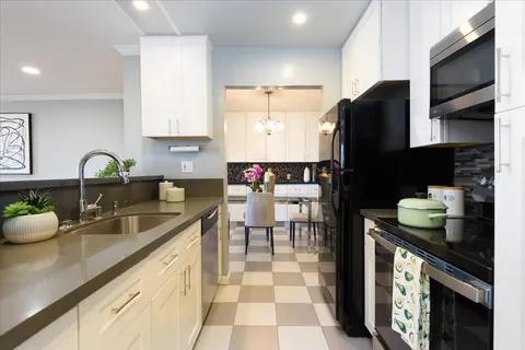 a kitchen with a sink dishwasher a stove and a refrigerator with wooden floor