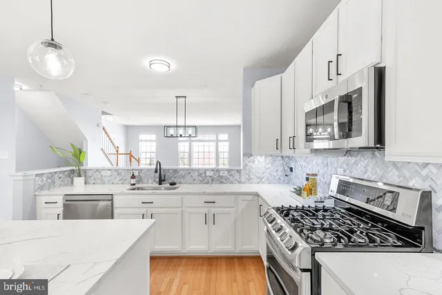a kitchen with stainless steel appliances a sink stove and cabinets