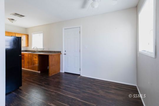 249 North Alvord Street Ridgecrest, CA 93555 - Photo 30 of 39 an empty room with wooden floor and windows