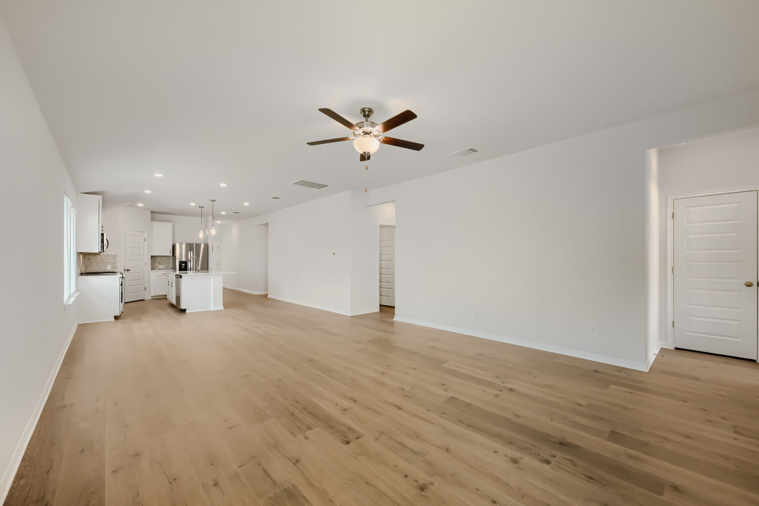 146 Diablo Rim Terrace Dripping Springs, TX 78620 - Photo 10 of 32 Beautiful floors flow through an open-concept living area and into a contemporary kitchen.