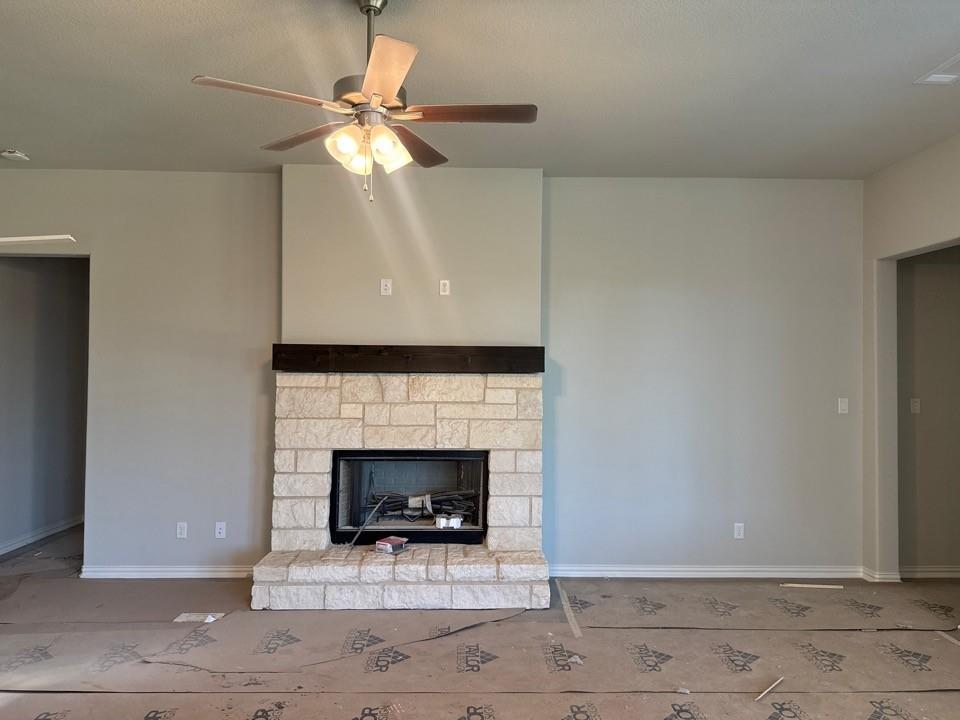 404 Guadalupe Lane Springtown, TX 76082 - Photo 5 of 9 a living room with a fireplace and a ceiling fan