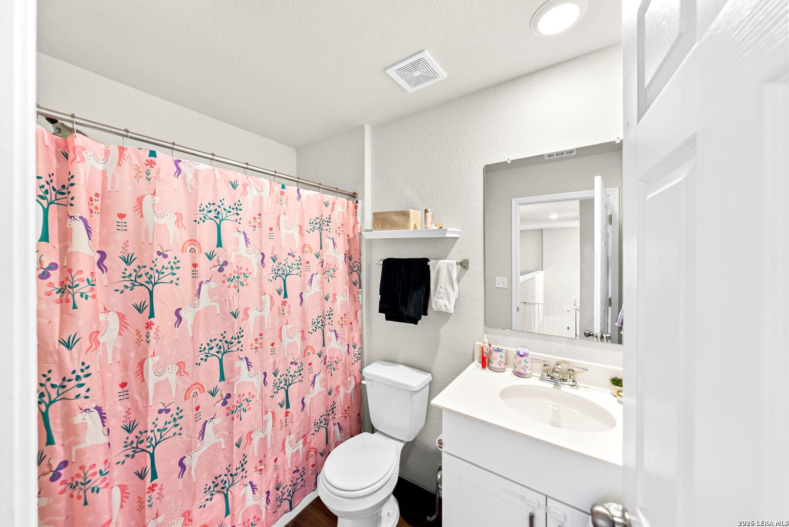 6710 Turnpike Converse, TX 78109 - Photo 23 of 34 a bathroom with a toilet sink a mirror and shower curtain