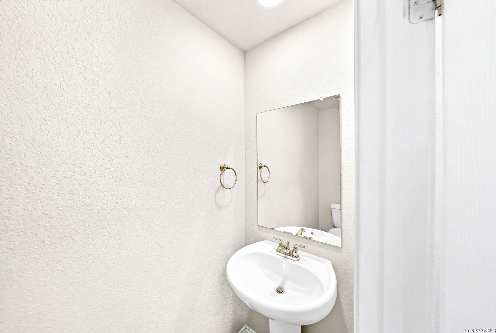 6710 Turnpike Converse, TX 78109 - Photo 24 of 34 a bathroom with a sink a mirror and a toilet