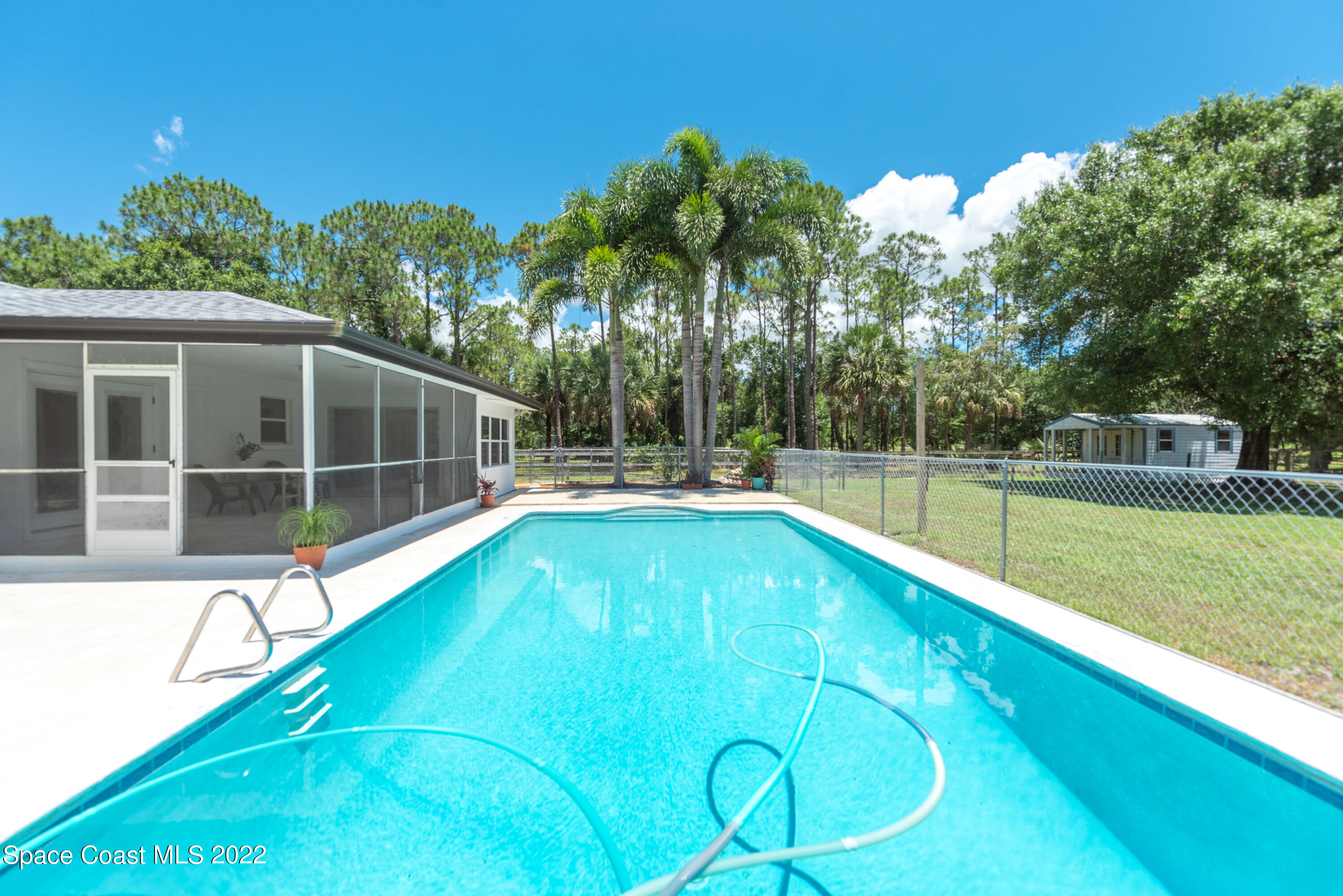 2085 Harlock Road Melbourne, FL 32934 - Photo 17 of 27 a view of a swimming pool with a garden and plants