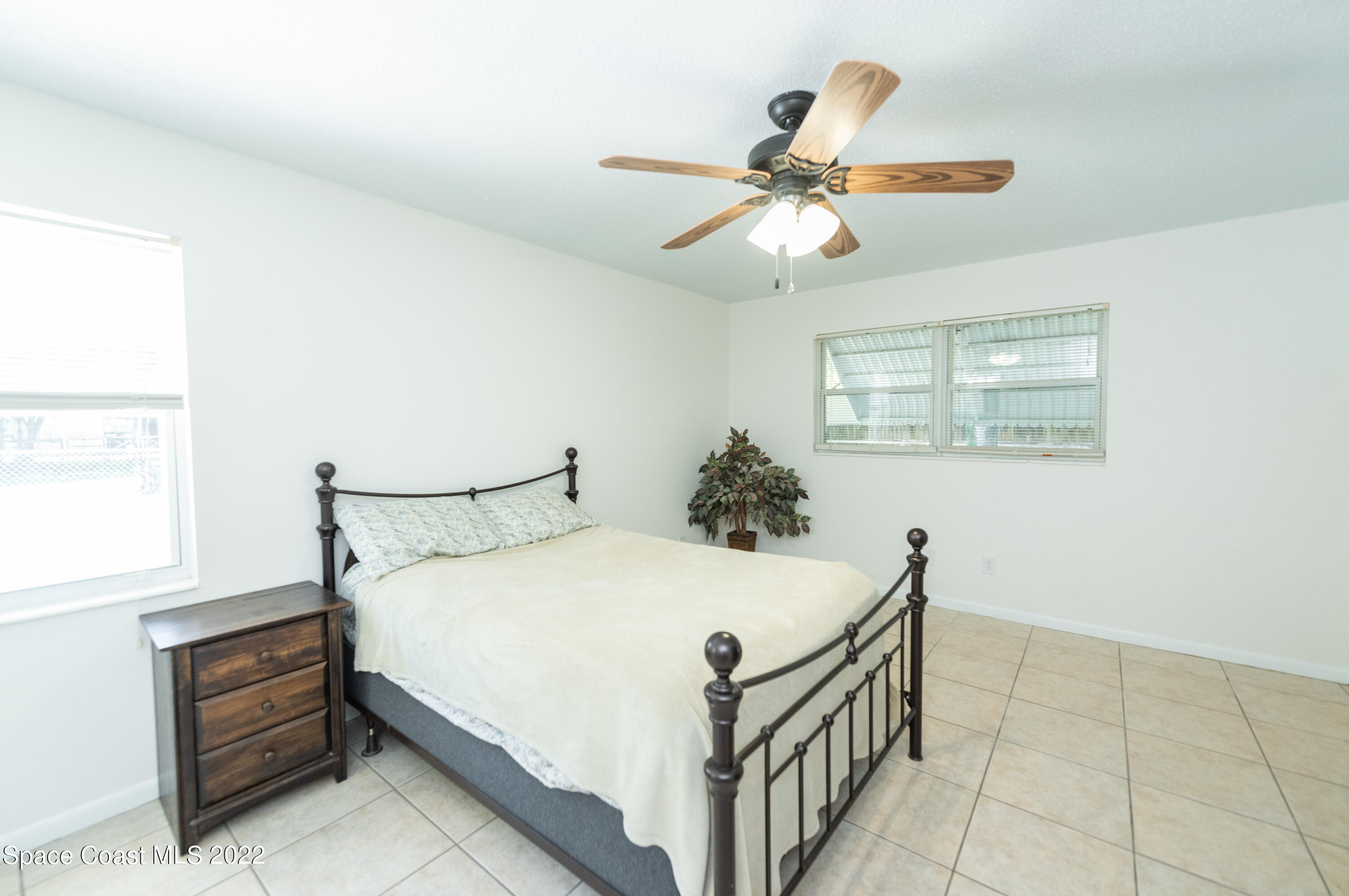 2085 Harlock Road Melbourne, FL 32934 - Photo 8 of 27 a bedroom with a bed and a chandelier