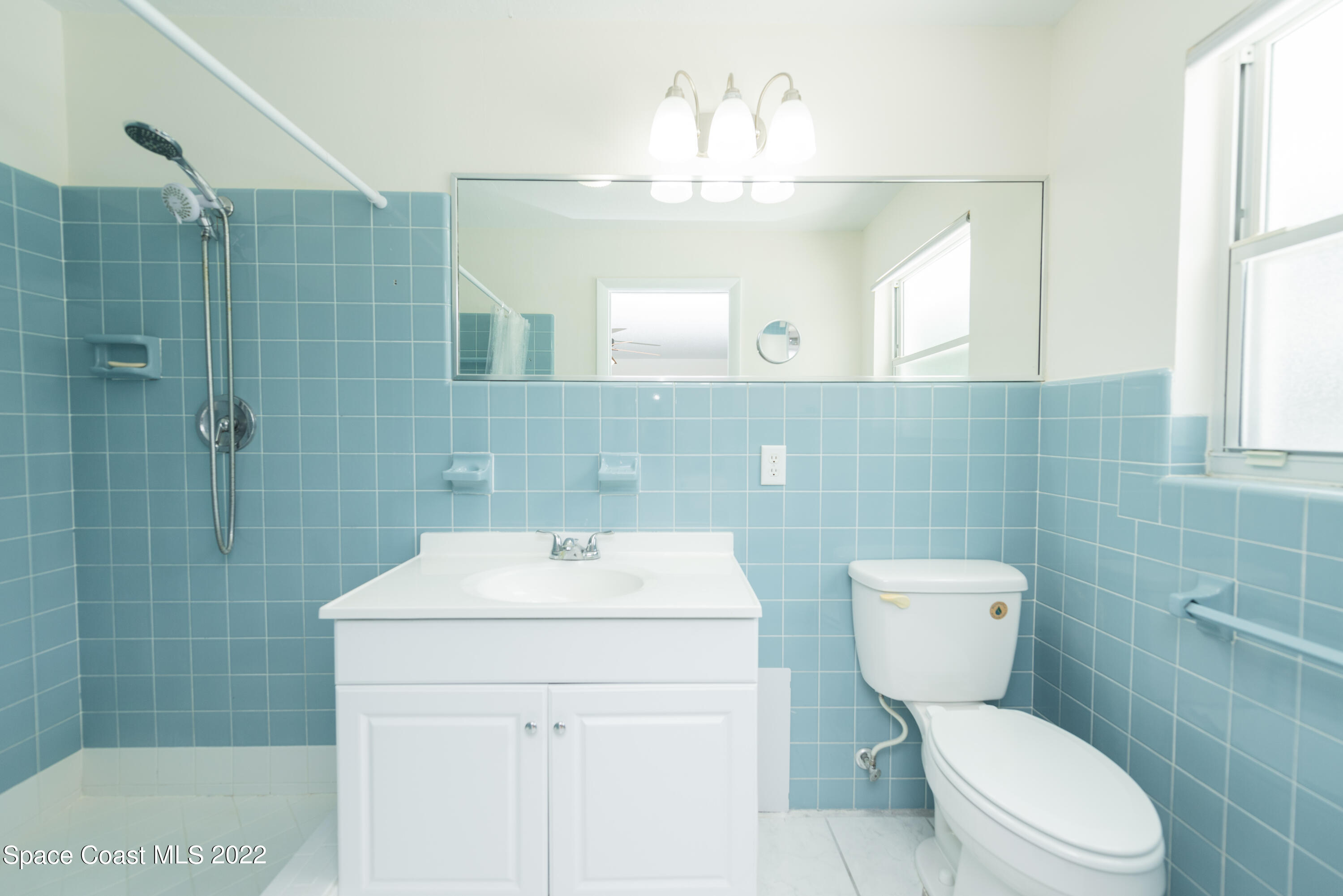 2085 Harlock Road Melbourne, FL 32934 - Photo 9 of 27 a bathroom with a toilet sink and mirror