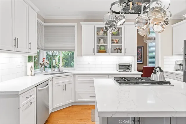 a kitchen with stainless steel appliances granite countertop a sink a stove and cabinets