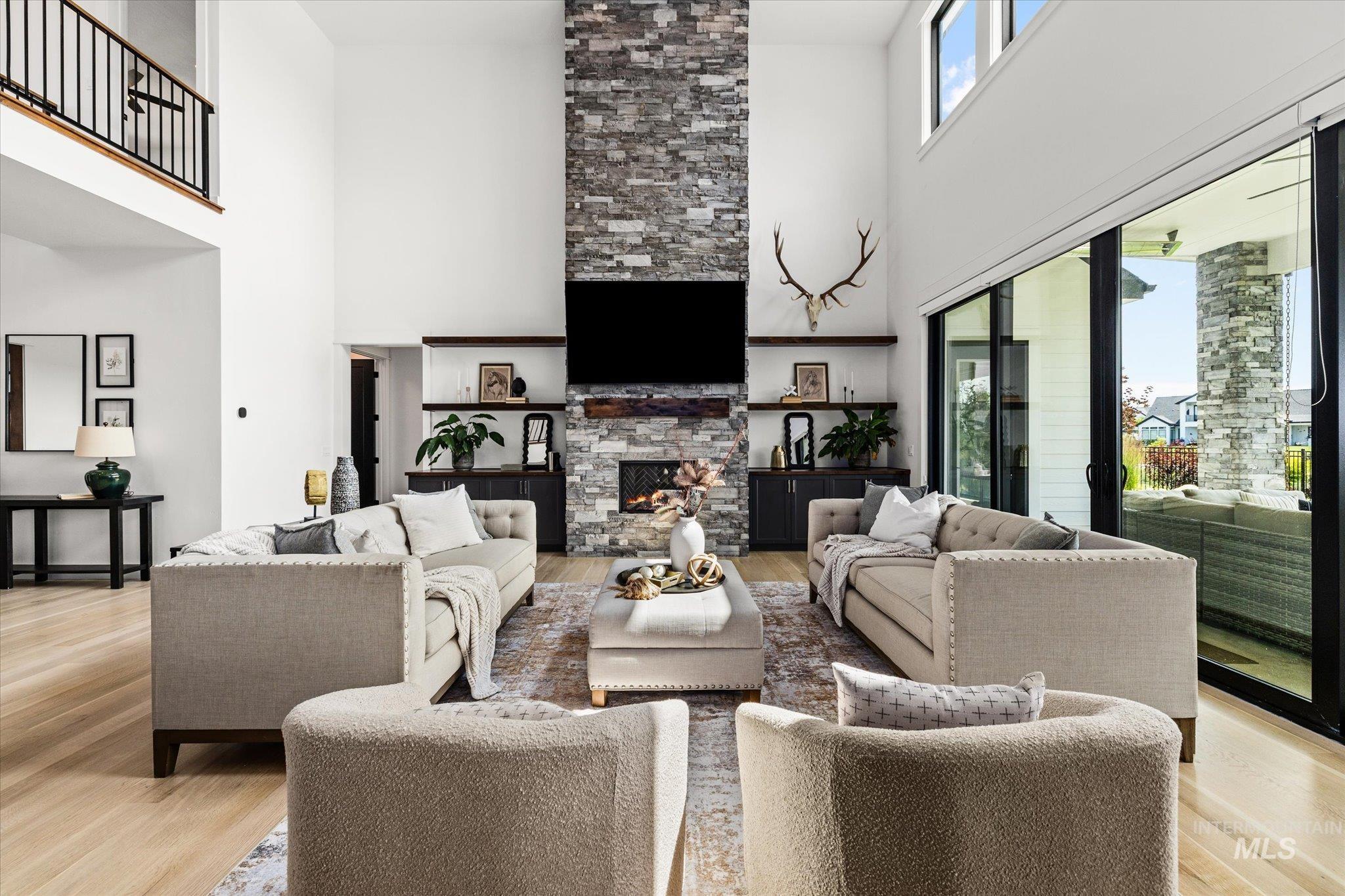 2248 South Trout Stone Way Eagle, ID 83616 - Photo 3 of 50 Living room featuring a towering ceiling, light wood finished floors, and a fireplace