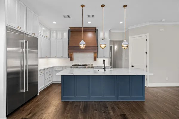 a kitchen with stainless steel appliances granite countertop a sink a stove and a refrigerator