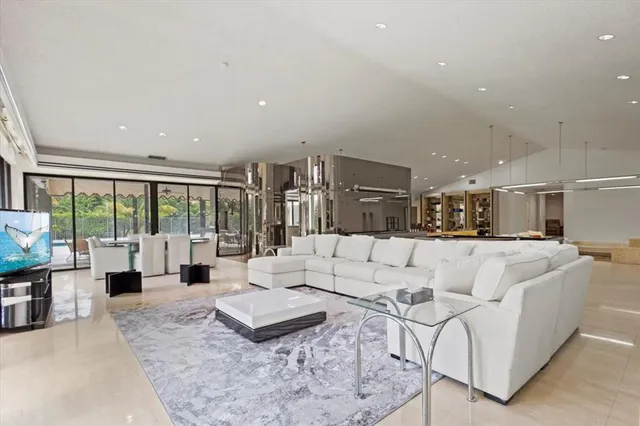 a living room with furniture a flat screen tv and a large window