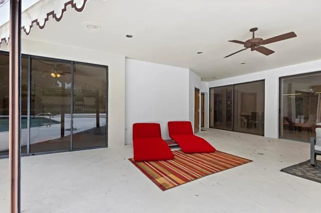 a view of a patio with a table chairs and a floor to ceiling window