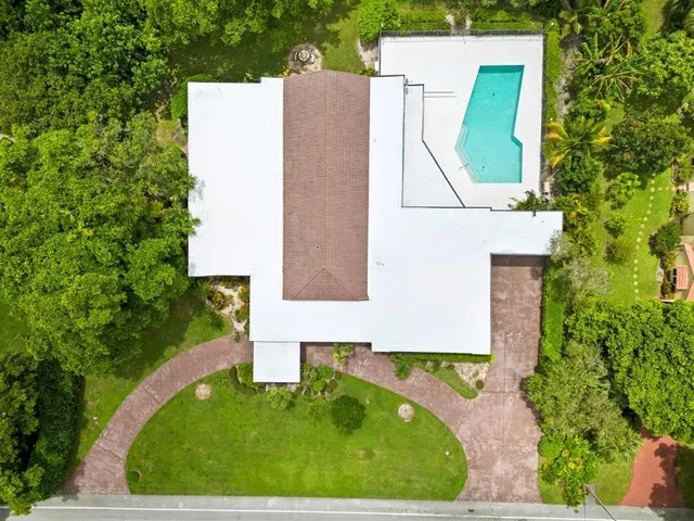 a aerial view of a house with a yard and trees