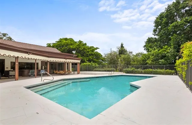 a living room with patio furniture and a large window