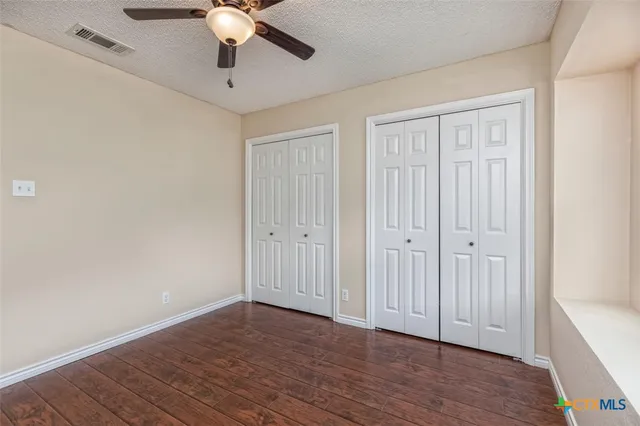 a bathroom with a granite countertop sink a toilet a mirror a vanity and shower