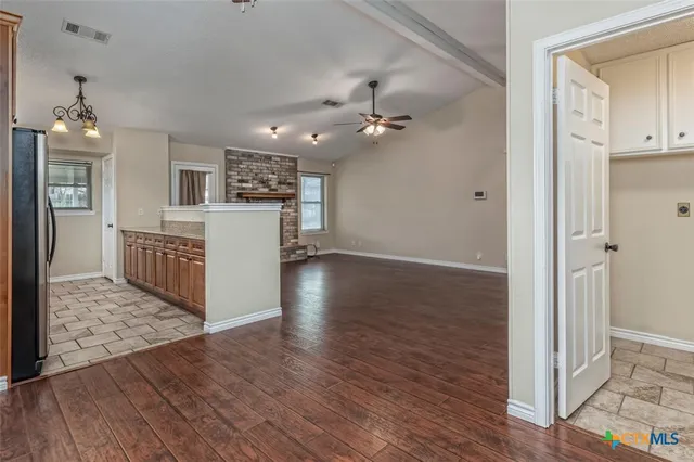a view of a kitchen with wooden floor and a ceiling fan