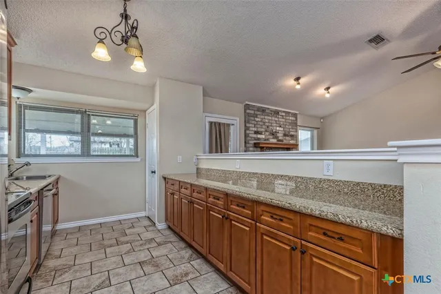 a kitchen with stainless steel appliances granite countertop a stove a sink and a microwave