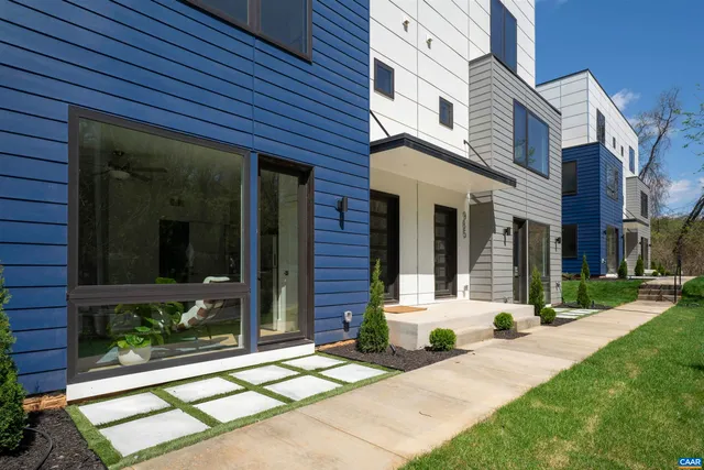 a view of a brick house with many windows next to a yard
