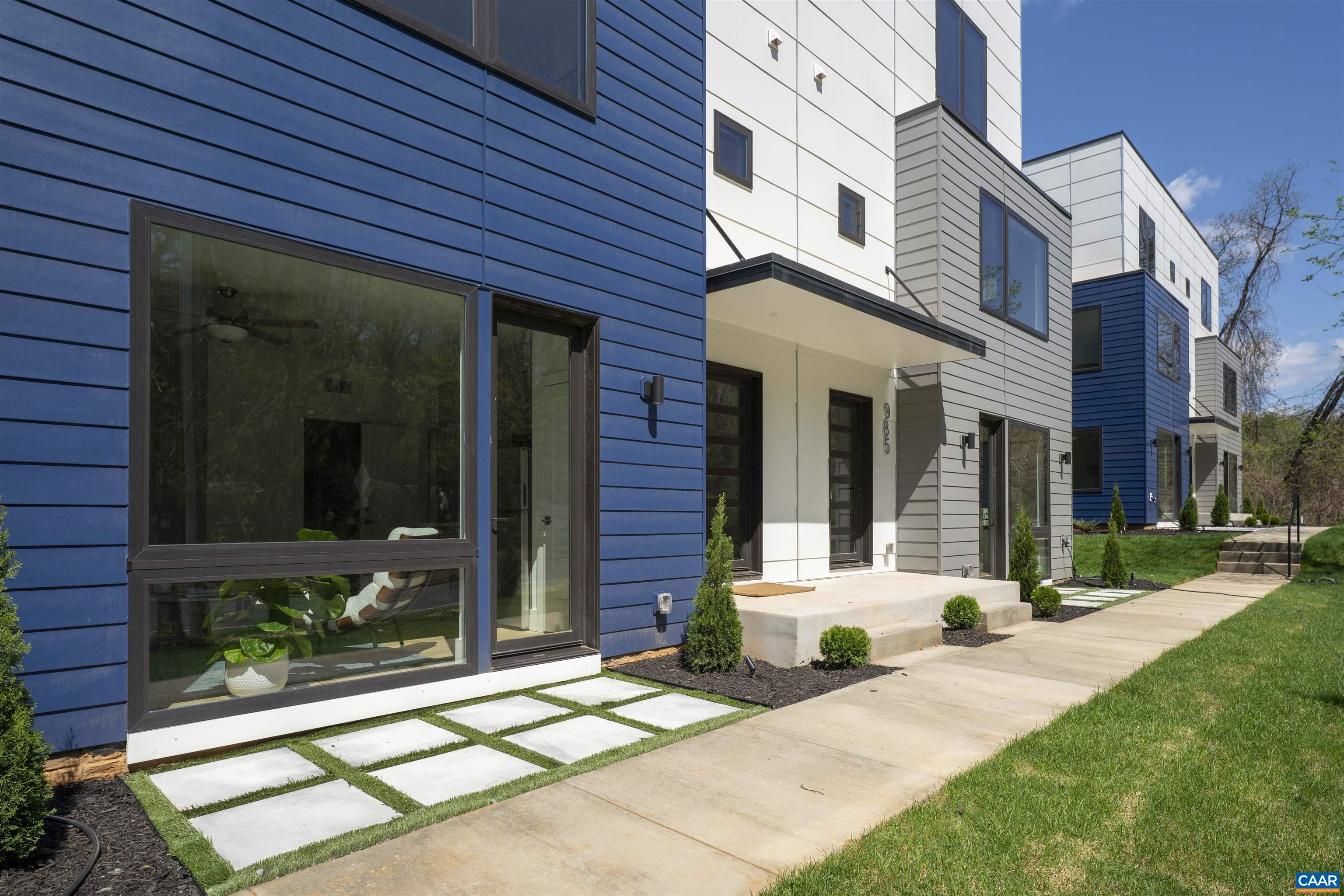 a view of a brick house with many windows next to a yard