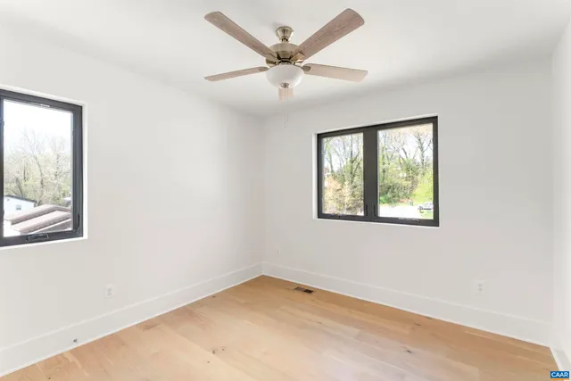 an empty room with a window and a ceiling fan