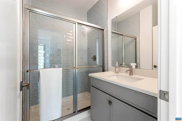 a bathroom with a sink mirror and shower