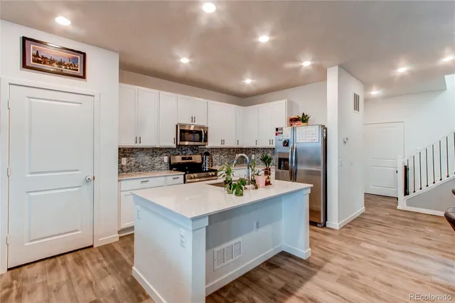 a kitchen with refrigerator cabinets and wooden floor