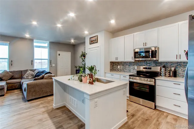 a kitchen with stainless steel appliances granite countertop a stove refrigerator and a sink